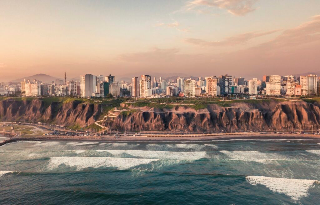 Skyline de Miraflores con departamentos de lujo frente al océano Pacífico al atardecer en Lima, Perú